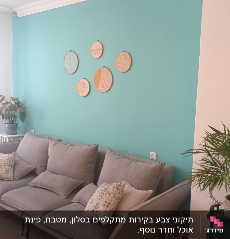 קיר צבוע בטורקיז עם עיגולים דקורטיביים תלויים